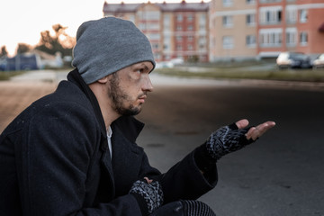 A man, homeless, a person asks for alms on the street with a Help sign. concept of homelessness,...