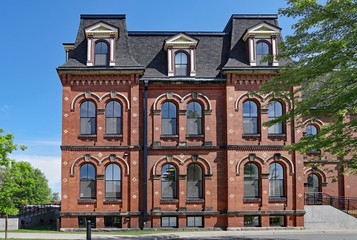 large old fashioned brick building with mansard roof and dormer windows, school or office building