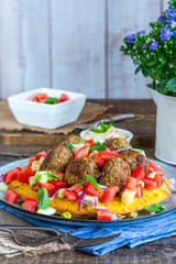 Curried chickpea cake with pistachio lamb meatballs and tomato sambal