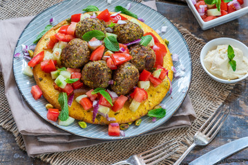 Curried chickpea cake with pistachio lamb meatballs and tomato sambal