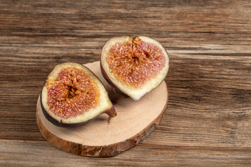 ripe fig fruit cut in half on a wooden table
