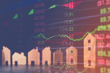 wooden house model on dark wood table double exposre with stock financial stock market  home...