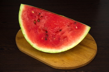 Fototapeta na wymiar Large slice of watermelon on a cutting board