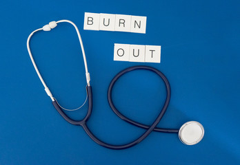 phonendoscope with writing burn out represents the concept of burn out for health personnel