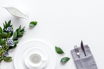 White plates and flowers for table setting on white background top view mock up