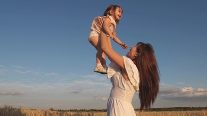 mother and little baby play on field of ripe wheat. happy family travels. Mom throws up a happy daughter in sky. baby in the arms of mom. happy family concept.