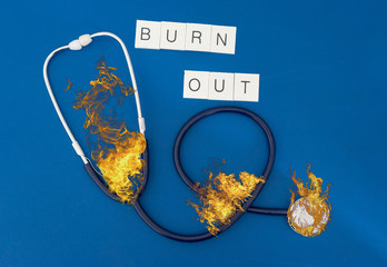 burning phonendoscope with writing burn out represents the concept of burn out for health personnel