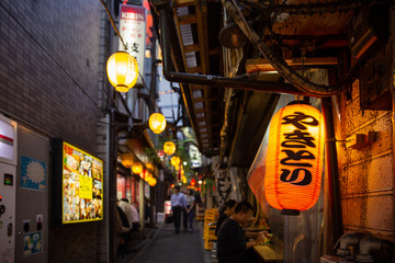 Yakitori-Gasse mit beleuchteten Laternen in Tokio am Abend
