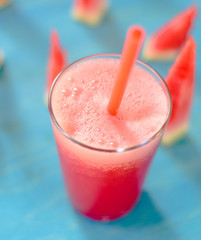 Watermelon smoothie with fresh watermelon slices on blue background