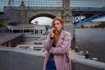 Fototapeta premium Portrait of beautiful redhair woman walking the city park.