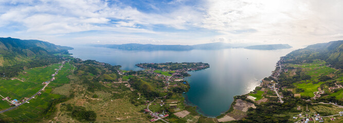 Fototapeta na wymiar Aerial: lake Toba and Samosir Island view from above Sumatra Indonesia. Huge volcanic caldera covered by water, traditional Batak villages, green rice paddies, equatorial forest.