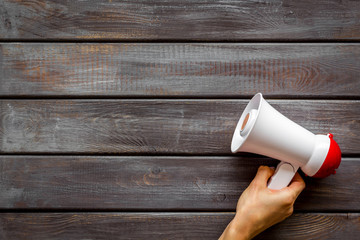 megaphone in hand for advertising and announcement on wooden background top view copyspace