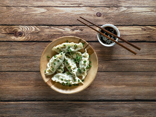 Homemade Meat Dumplings with soy sauce on wooden plate. 