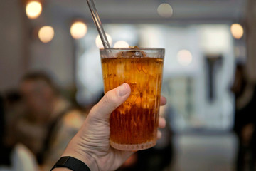 Handful glass of herbal ice tea with blur background and bokeh