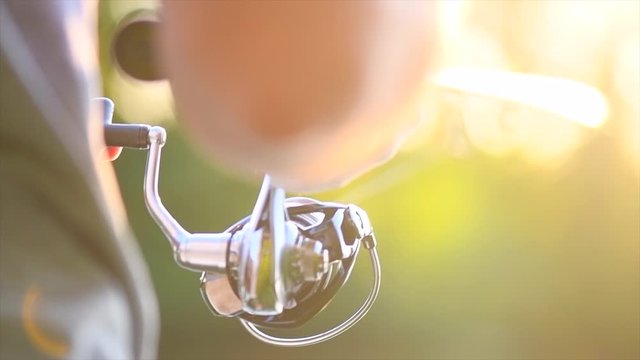 River fishing. Fisherman with a fishing rod on the river bank. Spinning. Fisher man catches a fish. Slow motion 4K UHD video footage. 3840X2160