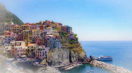 Fototapeta na wymiar MANAROLA, ITALY - JULY 4, 2019: Beautiful fishing village in Cinque Terre with colorful facades and sea view 