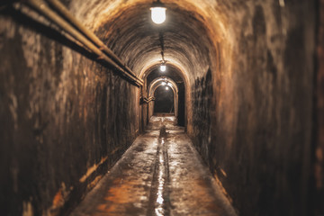 Fototapeta na wymiar long dark narrow underground tunnel with lighting