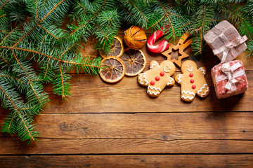 Christmas background with decorations : gingerbread cookies and fresh fir branches on wooden...