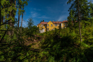 Fototapeta na wymiar Old hunting castle in forest in Krusne mountains in summer sunny day with creek