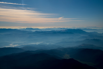 Beautiful sunrise aerial mountains landscape view. Mountain peak of rocks covered by clouds and fog. Mountain chain. Mountains with snow ridge. Highest mountains in world