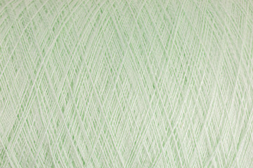 background of pastel green wool on a cone