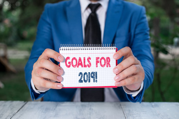 Word writing text Goals For 2019. Business photo showcasing object of demonstratings ambition or effort aim or desired result Man holds empty paper with copy space in front of him