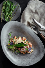 Olivier with crab meat in a beautiful bowl in the form of oysters, on a dark background. Food photo...