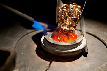 pieces of gold loaded into furnace for melting