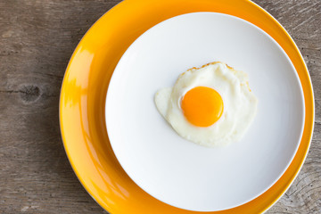 Fried egg on a white, yellow plate. Top view. Restaurant. Breakfast