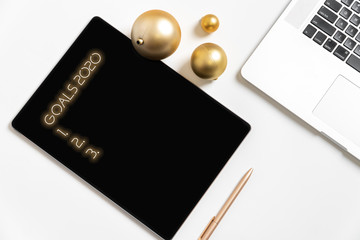 Christmas business desk with notebook, pen and golden balls. 2020 goals. Top view