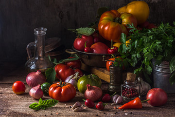 Ripe tomatoes with chili, onion and olive oil on a rustic table