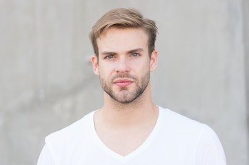 Obraz premium Przystojny mężczyzna kaukaski szare tło. Brodaty facet styl casual z bliska. Męskie standardy urody. Idealne cechy, które czynią mężczyznę atrakcyjnym fizycznie. Przystojny mężczyzna zarośnięty twarz stylową fryzurę