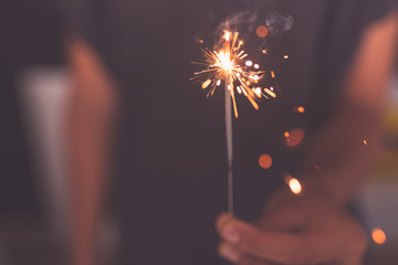young girl burning sparkler in hand
