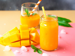 Mango smoothies glasses with fresh ripe mango for summer fruit drink concept.