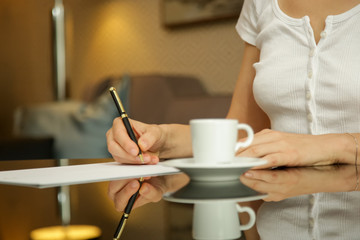 Fototapeta na wymiar Woman writing on a white sheet of paper