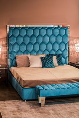 Modern interior, blue velvet bed in Art Nouveau style, crystal gold chandeliers, pink walls