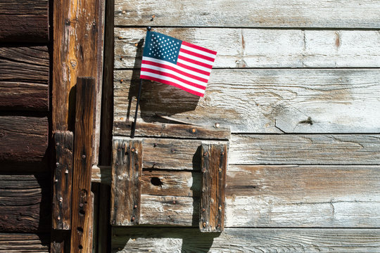 close up of a small American flag displayed on a vintage wooden barn door in Montana
