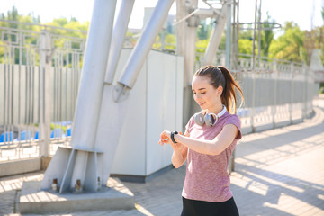 Sporty young woman checking her pulse outdoors