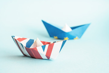 paper ships from the flags of the European Union and the UK on a blue background,  concept of an agreement on Brexit
