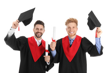 Young students in bachelor robes on white background