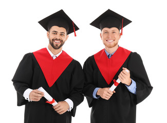 Young students in bachelor robes on white background