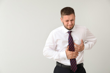 Businessman having panic attack on light background