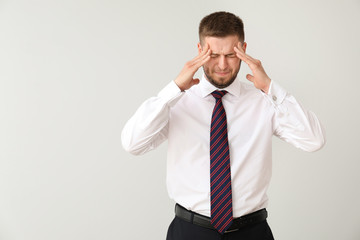 Businessman having panic attack on light background