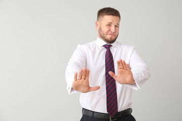 Businessman having panic attack on light background