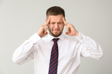 Businessman having panic attack on light background