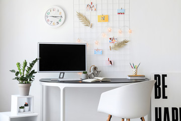 Workplace with mood board and computer in modern room
