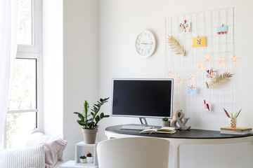 Workplace with mood board and computer in modern room