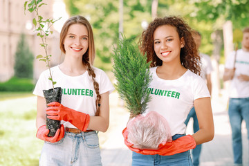 Female volunteers with young trees outdoors