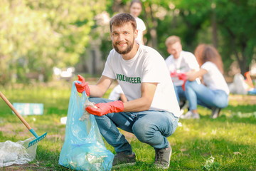 Male volunteer gathering garbage in park
