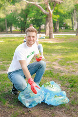 Male volunteer gathering garbage in park